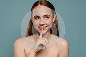 Half-naked ginger woman smiling and showing silence gesture