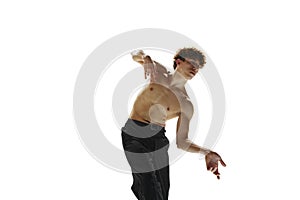 Half-naked, male ballet dancer in black pants freeze in moment of contemporary dance against white studio background.