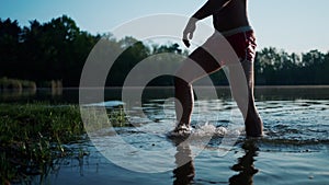 Half naked man going from the frozen lake with ice cold water