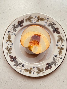 Half nectarine on Royal Doulton Burgundy plate.