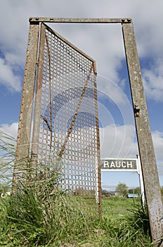 Half-open door in the middle of nowhere, and train station sign with the name Rauch