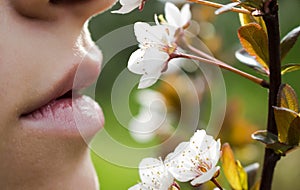 The half-open mouth of the girl who inhales the fragrance of cherry blossoms