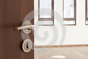 Half opened door to a ampty room. Door handle, door lock. Welcome, to new home concept