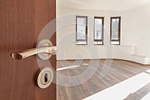 Half opened door to a empty room. Door handle, door lock. Welcome, to new home concept