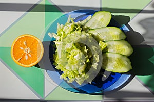 Half an orange next to a blue plate