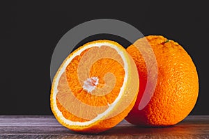 Half an orange. Two halves of fruit on a wooden table. Copyspace.