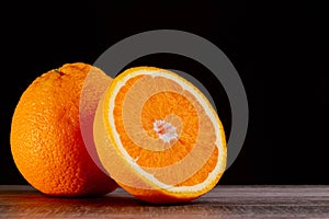 Half an orange. Two halves of fruit on a wooden table. Copyspace.