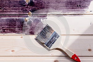 Half painted wooden surface. Black color. Varnishing natural wood with paint brush.Painting natural wood wall with brush