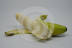 Half-peeled green banana (pisang ambon)