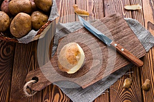 Half-peeled potatoes on a cutting board