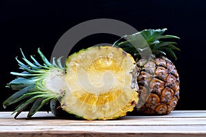 Half pineapple cut on a black background