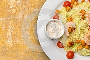 Half a plate of Caesar salad on textured table