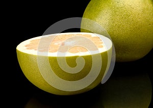 Half of pomelo, chinese grapefruit isolated on black