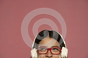 Half portrait of a beautiful happy woman in white headphones listens to music