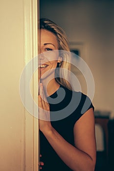 Half portrait of a beautiful smiling young lady in sunlight at home.