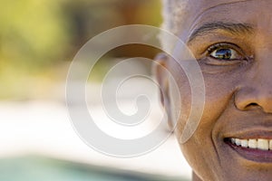 Half portrait of happy senior biracial woman smiling in sunny garden, copy space