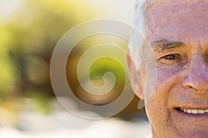 Half portrait of happy senior caucasian man smiling in sunny garden, copy space