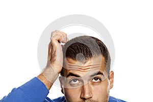 Half portrait of young confused man on white