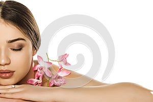 Half portrait of young woman with makeup  posing with orchids