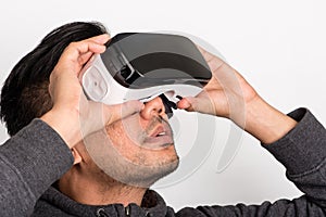 Half profile of young asian man holding virtual reality goggles