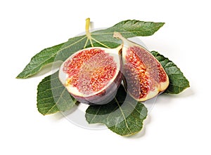 Half and quarter of a fresh ripe sweet fig fruit on a green fig leaf isolated on a white background. Design element for vegetarian