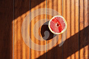 Half of red grapefruit lies on a wooden table. fresh fruits. healthly food