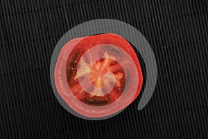Half a red tomato on a black background