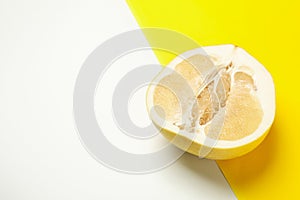 Half of ripe pomelo fruit on two tone background