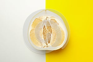 Half of ripe pomelo fruit on two tone background