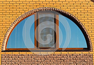 Half-round window in brick wall, house exterior, closeup