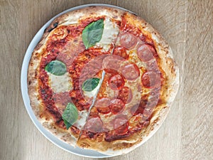 Half a salami pizza and half Margherita pizza with mozzarella, tomato sauce and basil. Fresh and crispy.