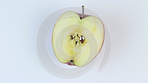 Half slised red apple rotating in the center of the frame on a white background