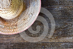 Half striped farmer hat made of woven bamboo on old wood background