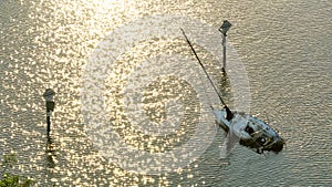 Half sunken sailing yacht capsized on shallow bay waters after hurricane Ian in Manasota, Florida