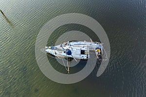 Half sunken sailing yacht capsized on shallow bay waters after hurricane Ian in Manasota, Florida