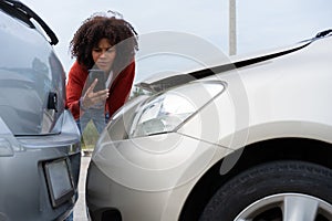 Half Thai African driver check for damage after a car accident before taking pictures and sending insurance. Online car accident