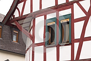 Half-timbered house with red wooden beams amd green windows Germany