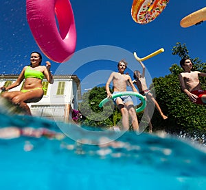 Half underwater shoot of kids group dive in pool