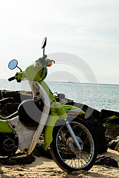A half of vintage green motorbike park on the beach, sea background
