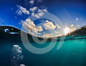 Half water shot of ocean water and sky with the sun above