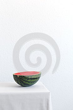Half of watermelon on a white table with copy space. Vertical