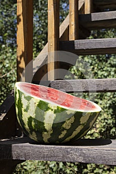 Half watermelon on wooden stairs, close up