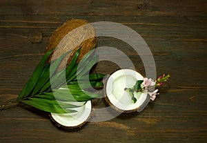 Half and whole coconuts. Coconut pattern on wooden background. Copy space