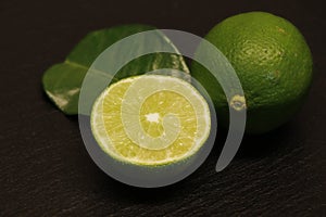 Half and whole lime isolated on a black background