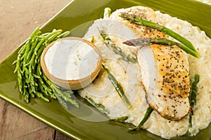 Halibut with asparagus risotto on green plate