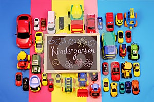 Ð¡halkboard with the inscription: Kindergarten, surrounded by colored cars on multicolored background