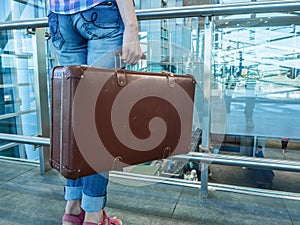 Hall Airport. A woman traveling with retro suitcase