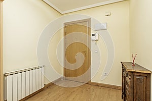 Hall of a house with Castilian-type wooden furniture, armored oak door, aluminum radiator and wooden floors