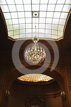 Hall in a mansion with a high domed ceiling. glass window with lattice texture. luxury chandelier. rich baroque interior photo