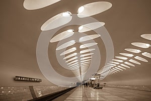 A hall of a modern metro station with perspective arrows of oval lights